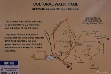 Signage at the Cultural Walk Trail warns visitors of harsh weather and electrified fences protecting a fauna reserve. [2704]