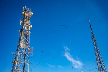 The mess of fine cables in front of the microwave tower at left, is a legacy HF (high frequency) or shortwave antenna array used in the mid 20th century for long‑distance radio communication. for telegraphy, voice, and data links between remote Australian outposts and major centres. [0852]
