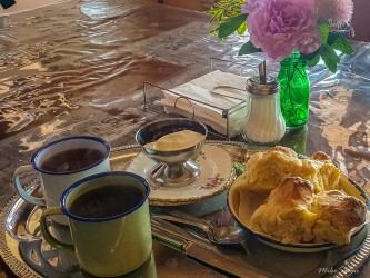 Scones, enamel mugs, and a pink flower — a touch of comfort amid the red dust of mining history, all included on the mine tour fee. [1028]