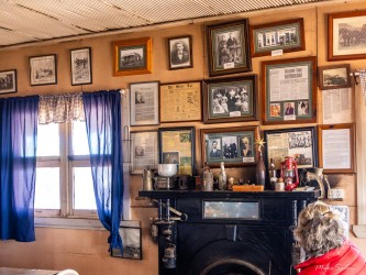 Walls lined with photographs and memorabilia — miners’ stories preserved in frames and fading paper. [2953]