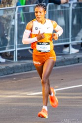 Ethiopian runner Mesfin powering through Taylor Square during the 2025 Sydney Marathon. The early‑morning light highlights her focus and rhythm as she leads the women’s field past cheering spectators. [5226]