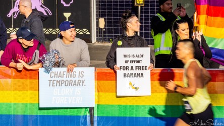 Cheer squad at Taylor Square during the 2025 Sydney Marathon, holding witty motivational signs and rainbow banners as runners pass. Their mix of humour and support captures the inclusive spirit of the event. [5254]
