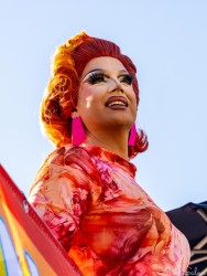 A drag performer at Taylor Square during the 2025 Sydney Marathon, radiant in red and pink under the morning sun. Her confident pose and vivid styling embody the joyful spirit that defines Oxford Street’s celebration of diversity. [5298]